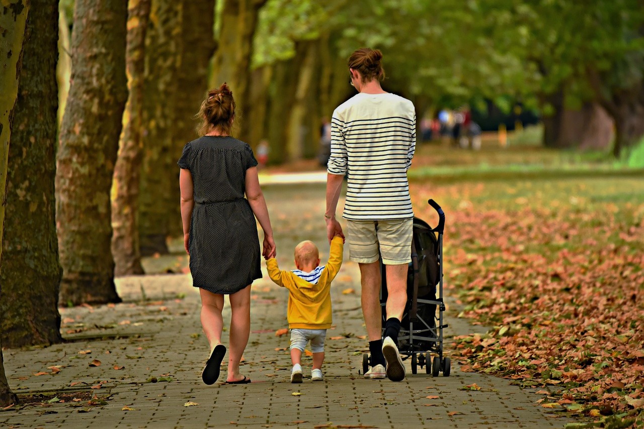 ouders lopen met kind door het park